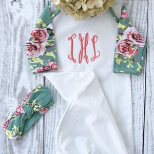 May include: A white knotted gown with floral print sleeves and a matching headband. The gown has a monogrammed "IHL" on the front.