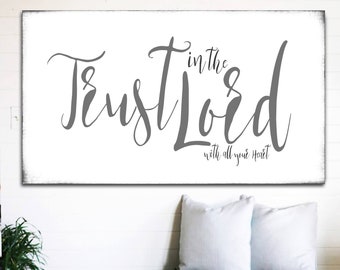 May include: A white wooden sign with the text "Trust in the Lord with all your heart" in gray script font.