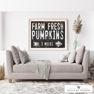 May include: A black and white sign with a distressed metal texture reads "Farm Fresh Pumpkins" with an arrow pointing right and the text "3 Miles".