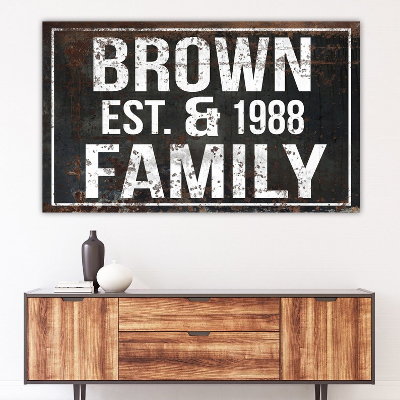 Puede incluir: Un letrero en blanco y negro con una textura de metal desgastado. El letrero dice "BROWN EST. & 1988 FAMILY".