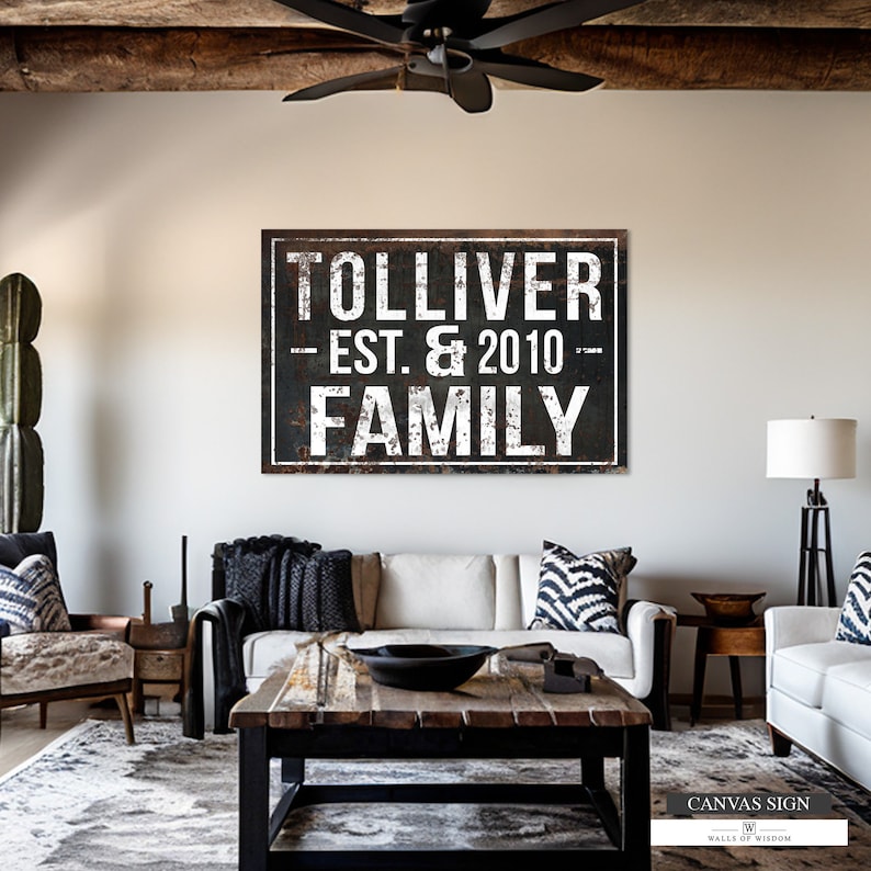 Puede incluir: Un letrero de lona en blanco y negro con un aspecto de metal desgastado. El letrero dice "Tolliver Est. & 2010 Family".