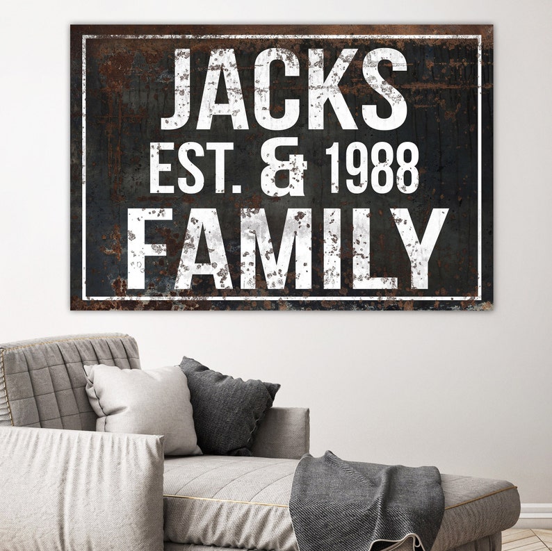 Puede incluir: Un letrero en blanco y negro con textura de metal oxidado. El letrero dice "Jacks Est. & 1988 Family".