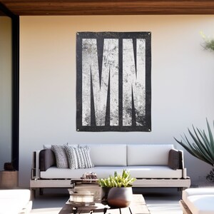 May include: A black and white tapestry with the word "MIN" printed in large, white letters. The letters have a distressed, vintage look.