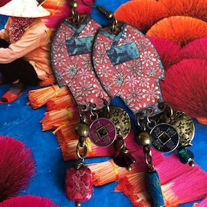 Könnte beinhalten: Ein Paar Ohrringe mit einem pinkfarbenen und blauen Kimono-Design und baumelnden Anhängern. Die Anhänger bestehen aus einer roten und blauen Münze mit chinesischen Schriftzeichen, einem roten Edelstein und einem blauen Edelstein.