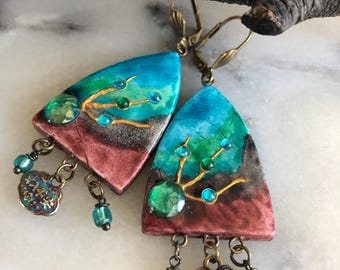 Pendientes bohemios, veraniegos y ligeros de arcilla en tonos azules, verdes y marrones, con cuentas de cristal y coloridos dijes chinos. Regalo ideal para el verano.