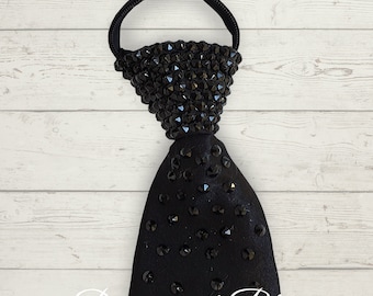 May include: Black tie with black rhinestones. The tie has an elastic band at the top and the text " Dancesport Bling" is visible at the bottom of the image.