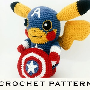 Op de afbeelding: Haakpatroon voor een Pikachu verkleed als Captain America, die een rood, wit en blauw schild vasthoudt. De Pikachu draagt een blauw en wit kostuum met een rode ster op de borst.