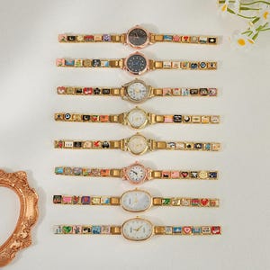 Peut inclure: Une sélection de sept montres dorées avec des bracelets à breloques décoratifs. Les cadrans des montres sont ronds ou ovales, avec diverses couleurs et motifs. Les bracelets présentent des images miniatures colorées.