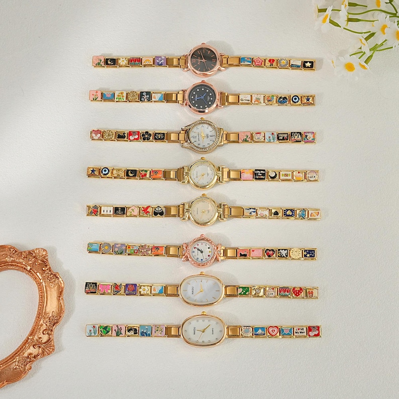May include: An assortment of seven gold-toned watches with decorative charm bracelets. The watch faces are round or oval, with various colors and designs. The bracelets feature colorful, miniature images.