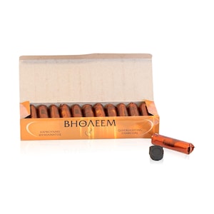 Puede incluir: Una caja abierta de carbón de encendido rápido con la marca "BHOΛEEM" en letras blancas. La caja es naranja y marrón, con piezas individuales de carbón envueltas en papel de aluminio naranja. Un disco de carbón se encuentra al lado.