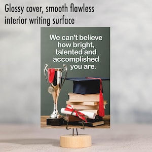 May include: A graduation card with a gold trophy, a graduation cap, and a diploma scroll. The card has a green background and the text "We can't believe how bright, talented and accomplished you are."