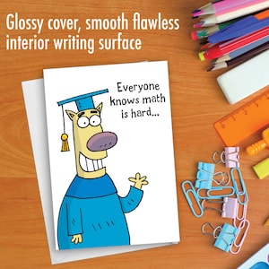 May include: A white card with a cartoon illustration of a yellow dog wearing a blue graduation cap and gown. The text on the card reads "Everyone knows math is hard..."