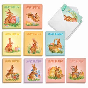 May include: A collection of ten rectangular greeting cards featuring illustrations of brown rabbits in various poses with colorful Easter eggs, grass, and baskets. Each card displays the text Happy Easter in a decorative font and includes a white envelope.