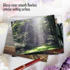 May include: A stack of blank greeting cards with a glossy cover and a smooth, flawless writing surface. The cards feature a variety of nature scenes, including a forest path, a field, and a wooded area.