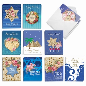 May include: A collection of Passover greeting cards featuring blue backgrounds, matzah patterns, floral arrangements, Stars of David, pyramids, and wine glasses. The cards include the text Happy Passover in English and Hebrew script, with white envelopes.