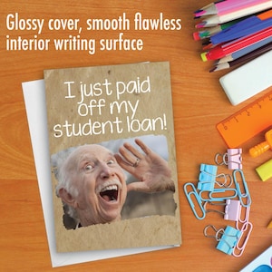 May include: A greeting card with a humorous image of an older person with a surprised expression. The card reads "I just paid off my student loan!"