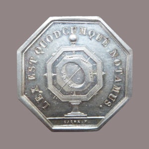 Puede incluir: Una medalla octogonal de plata con un diseño de brújula y la inscripción "LEX EST QUOD CUMQUE NOTAMUS".