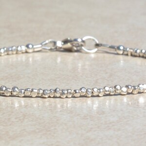 Puede incluir: Un brazalete de plata hecho de peque&ntilde;as cuentas texturizadas. El brazalete tiene un cierre de langosta.