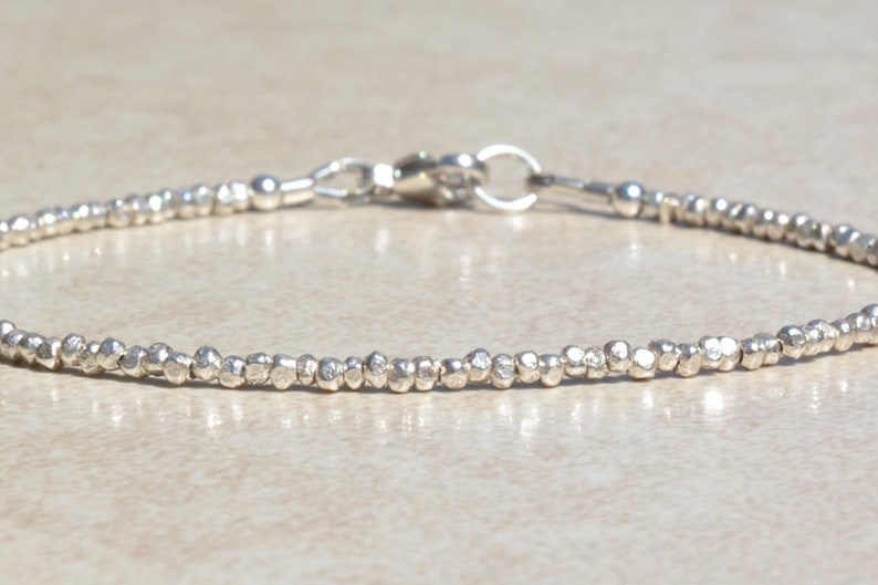 Puede incluir: Un brazalete de plata hecho de peque&ntilde;as cuentas texturizadas. El brazalete tiene un cierre de langosta.
