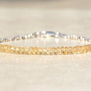 May include: A delicate bracelet featuring a row of small, light yellow citrine beads interspersed with silver beads. The bracelet has a silver clasp.
