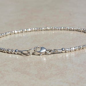 Puede incluir: Un brazalete de plata hecho de peque&ntilde;as cuentas texturizadas. El brazalete tiene un cierre de langosta.