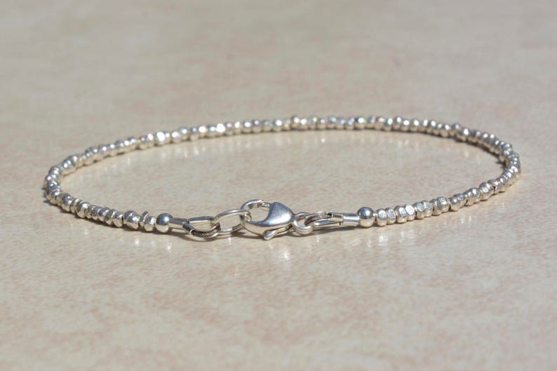 Puede incluir: Un brazalete de plata hecho de peque&ntilde;as cuentas texturizadas. El brazalete tiene un cierre de langosta.