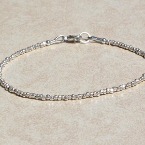Puede incluir: Un brazalete de plata con cuentas y cierre de mosquet&oacute;n.