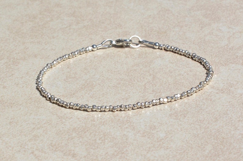 Puede incluir: Un brazalete de plata con cuentas y cierre de mosquet&oacute;n.