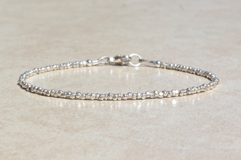 Puede incluir: Un delicado brazalete de plata hecho de peque&ntilde;as cuentas texturizadas. El brazalete tiene un cierre simple.