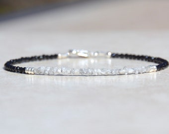May include: A delicate bracelet with black onyx beads and a row of white rough diamonds.