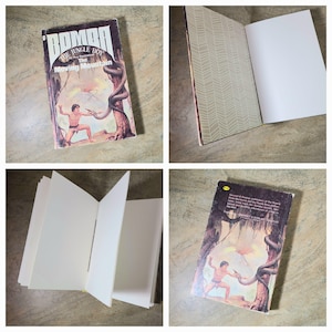May include: A hardcover book titled Bomba The Jungle Boy: The Moving Mountain by Roy Rockwood. The cover features an illustration of a boy in a jungle setting with a large snake. The book has blank white interior pages and patterned endpapers.