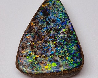 May include: A dark brown, green, and blue iridescent opal gemstone with a teardrop shape.