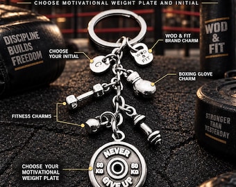 Puede incluir: Un llavero de metal plateado con una anilla circular, un dije de guante de boxeo, dos dijes de mancuernas, un pequeño dije redondo con la letra C, un dije de la marca WOD & FIT y un dije de disco de pesas grabado con NEVER GIVE UP 60 KG.
