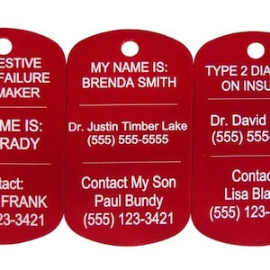 May include: Three red metal dog tags with white text. The first tag reads "Congestive Heart Failure Pacemaker, My Name Is: Bill Brady, Contact: Karen Frank (555) 123-3421". The second tag reads "My Name Is: Brenda Smith, Dr. Justin Timber Lake (555) 555-5555, Contact My Son Paul Bundy (555) 123-3421". The third tag reads "Type 2 Diabetic On Insulin, Dr. David Smith (555) 555-5555, Contact Lisa Black (555) 123-3421".