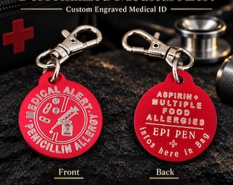 May include: Two round red metal medical alert tags with silver lobster claw clasps. The front tag features a syringe, vial, and pill icons with the text MEDICAL ALERT PENICILLIN ALLERGY. The back tag reads ASPIRIN + MULTIPLE FOOD ALLERGIES EPI PEN.