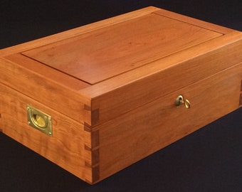 Custom dovetailed jewelry box from solid cherry wood with brass hardware, velvet liners, key locks, varnish, and individualized dividers.