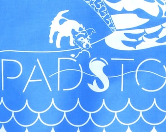 Padstow Tea Towel, Beautiful Cobalt blue, craft printed UK on 100% cotton. Jack Russel Terrier examines a fish in Padstow Harbour.