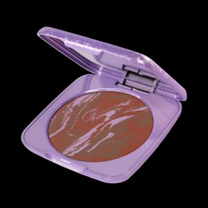 Op de afbeelding: Een compact met een paarse deksel en een swirl van bruine en roze blush erin.