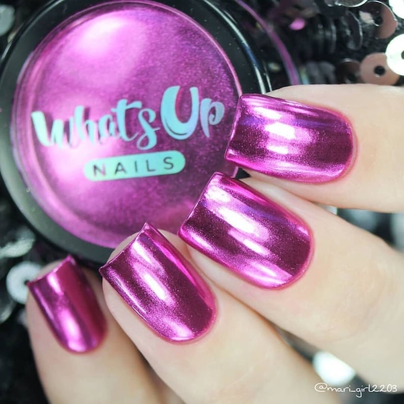 K&ouml;nnte beinhalten: Nahaufnahme von vier Fingern&auml;geln, die mit einem leuchtend metallischen rosa Nagellack lackiert sind. Der Lack ist sehr gl&auml;nzend und reflektiert das Licht. Die N&auml;gel sind alle unterschiedlich lang und geformt. Das Bild zeigt auch ein kleines Glas Nagellack mit der Aufschrift "Whats Up Nails" auf dem Etikett.