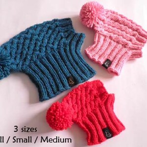 May include: Three knitted hats with pom-poms in blue, pink, and red. The hats are available in three sizes: X-Small, Small, and Medium.