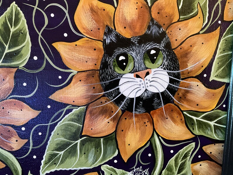 May include: A black cat with green eyes peeks out from a sunflower with orange and brown petals. The background is a dark purple with white dots and green leaves.