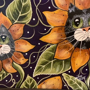 May include: Two black cats with green eyes are painted as sunflowers. The sunflowers are orange and yellow with green leaves. The background is a dark purple with white dots.