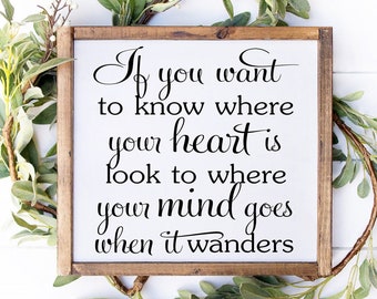 May include: A white wooden sign with a brown frame, featuring the quote "If you want to know where your heart is, look to where your mind goes when it wanders."
