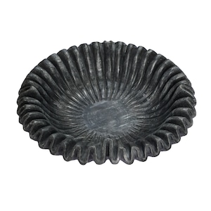 Może przedstawiać: Czarna, falbaniasta, okrągła miska dekoracyjna wykonana z kamienia.