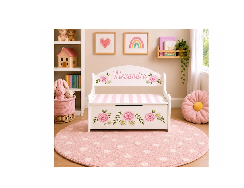 May include: A white wooden toy chest bench with a hinged lid, featuring a pink and white striped seat. The backrest is personalized with the name Alexandra in pink script, surrounded by floral illustrations of pink peonies and green leaves.