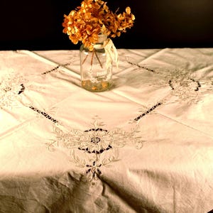 Toalha de mesa bordada à mão em algodão branco com estampa floral e recortes, estilo vintage dos anos 70, ideal para decoração de casamento shabby chic.