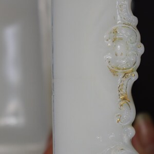 Puede incluir: Caja de porcelana blanca para alhajas con detalles dorados y un dise&ntilde;o decorativo. La caja tiene una tapa con bisagras y est&aacute; hecha de un material delicado.