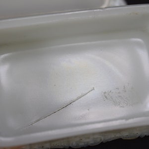 Puede incluir: Caja de cer&aacute;mica blanca para baratijas con una peque&ntilde;a grieta en el interior. La caja tiene un exterior texturizado.