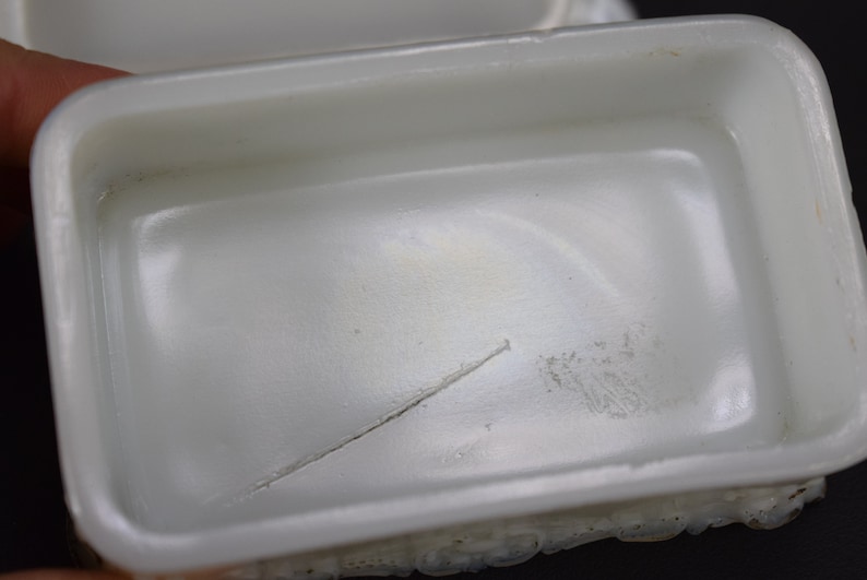 Puede incluir: Caja de cer&aacute;mica blanca para baratijas con una peque&ntilde;a grieta en el interior. La caja tiene un exterior texturizado.