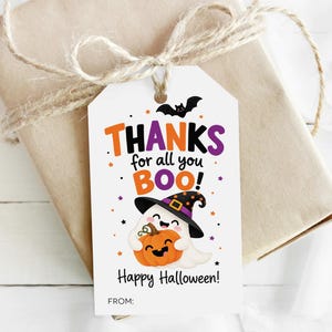 May include: A white rectangular gift tag featuring a cartoon ghost wearing a witch hat and holding a pumpkin. The text reads THANKS for all you BOO! Happy Halloween! FROM: with orange, purple, and black accents including a bat and stars.